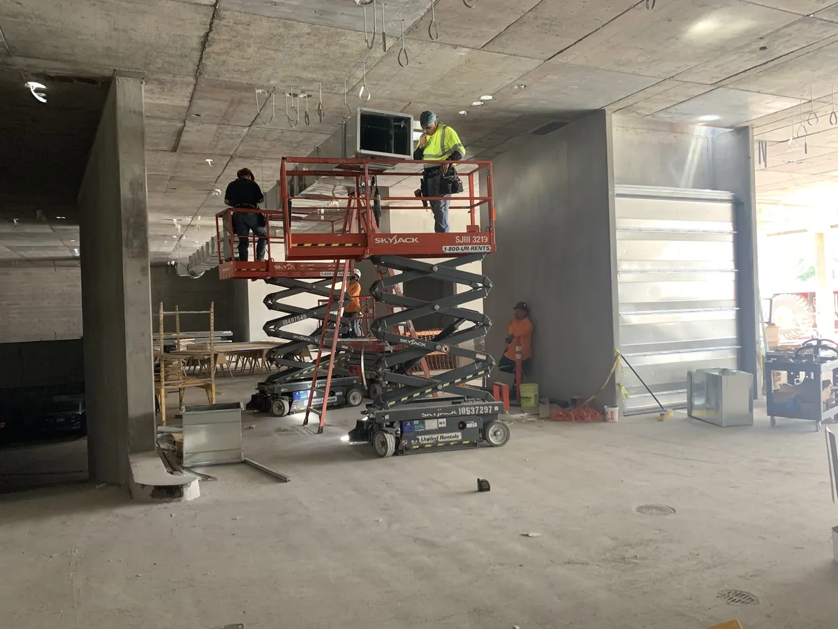 Air Plus crew working from lifts inside a building under construction.