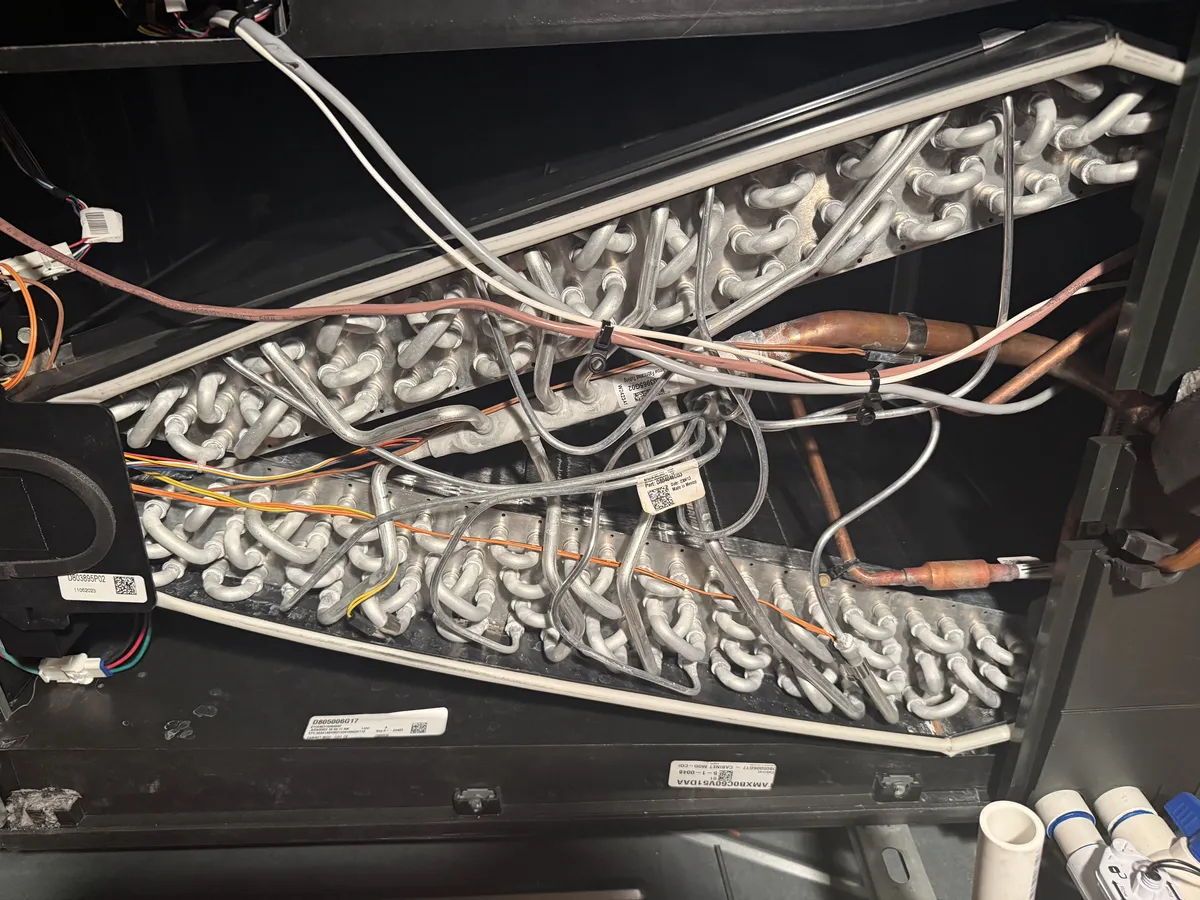 Open equipment panel with a finned coil and bundles of wires.