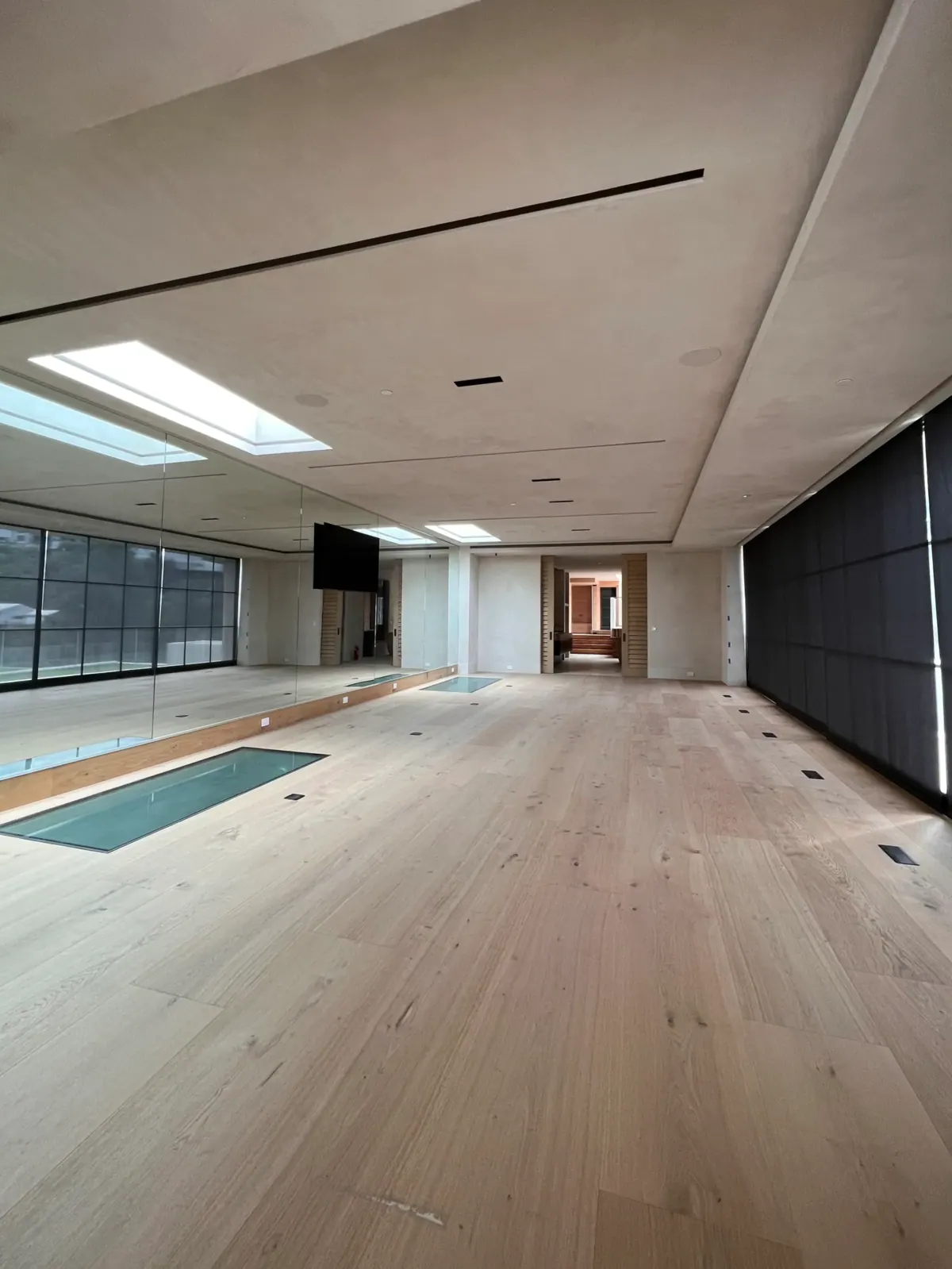 Long oak-floored room seen from one end, with skylights overhead.