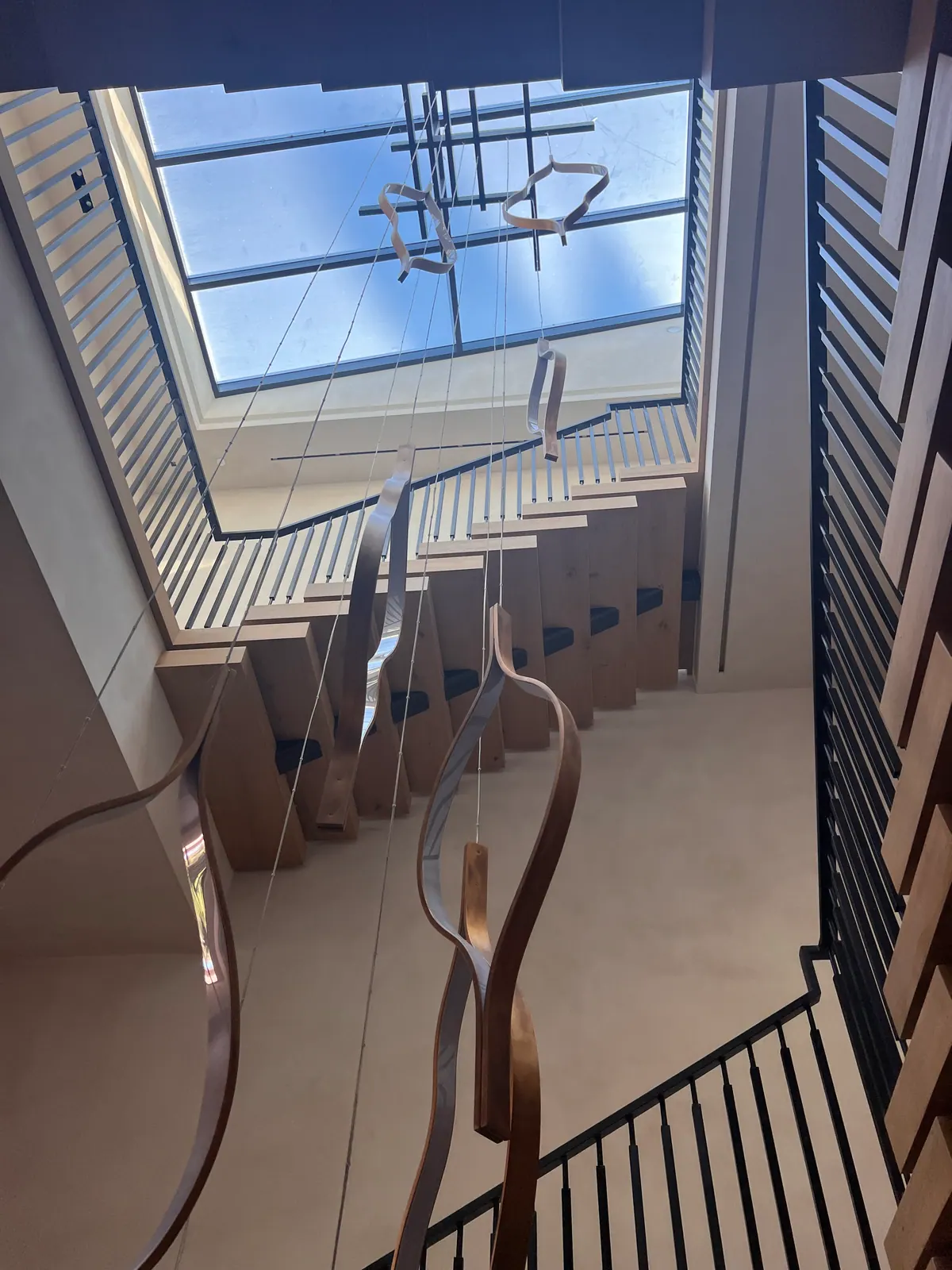 Looking down a staircase with oak treads beneath a skylight.