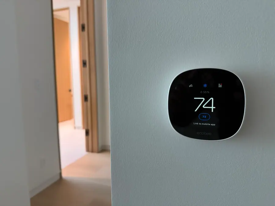A wall thermostat reading 74 degrees.