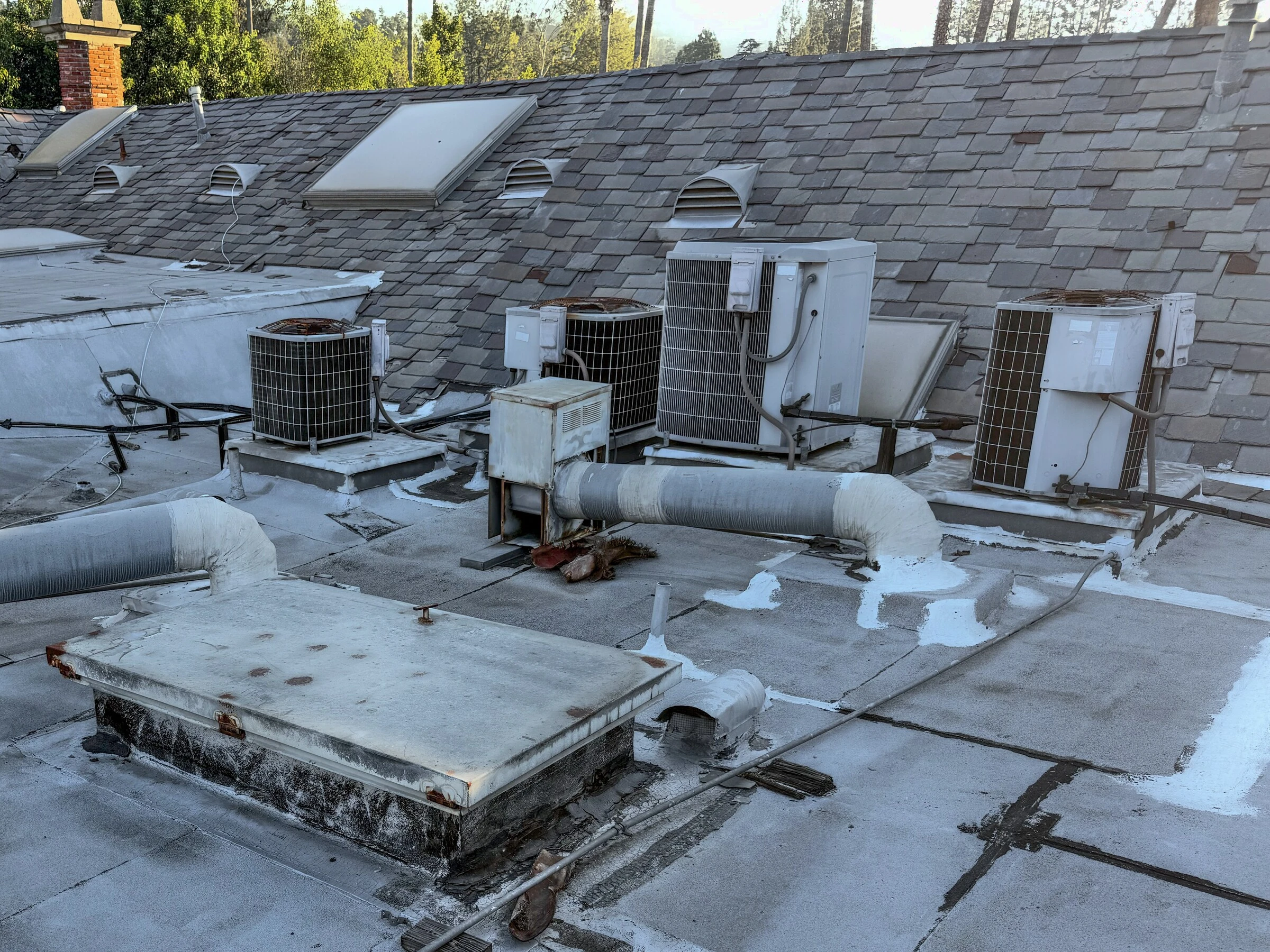 Older rooftop condensers with rusted cabinets and patched ductwork.