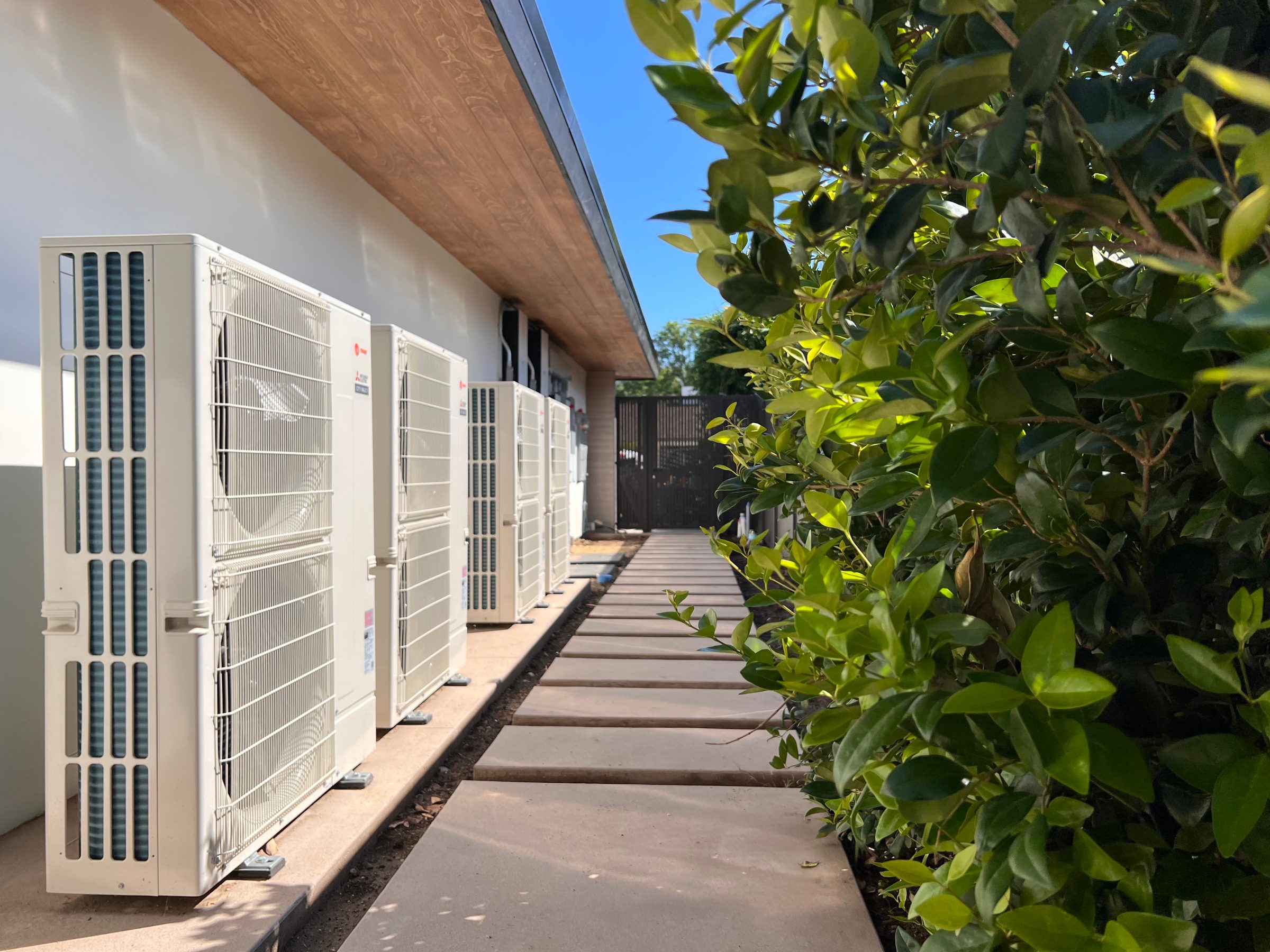 Outdoor units along a residential side yard.