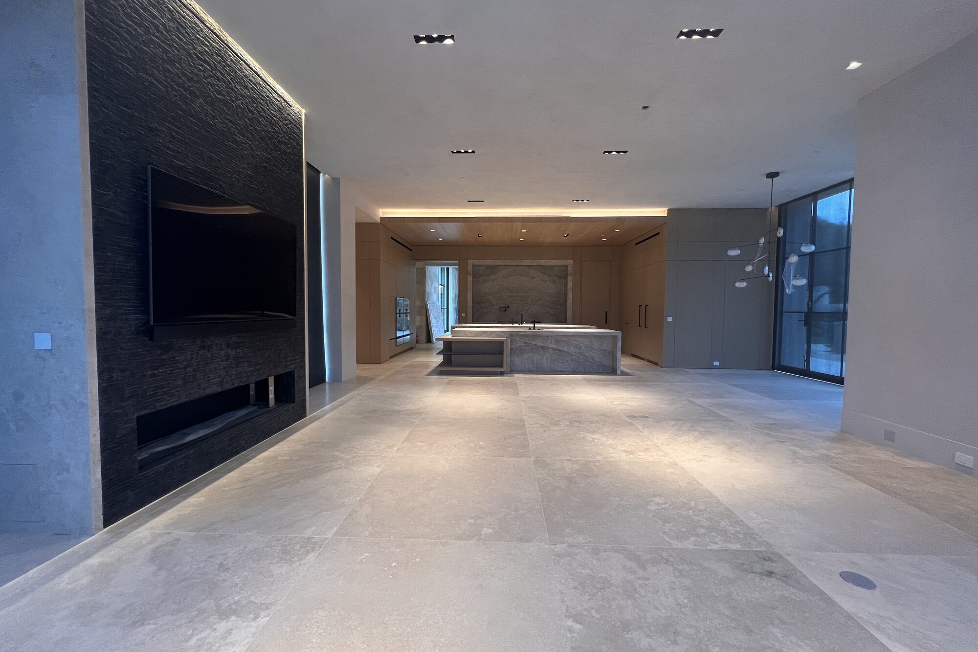 Kitchen and living room with a stone fireplace wall.