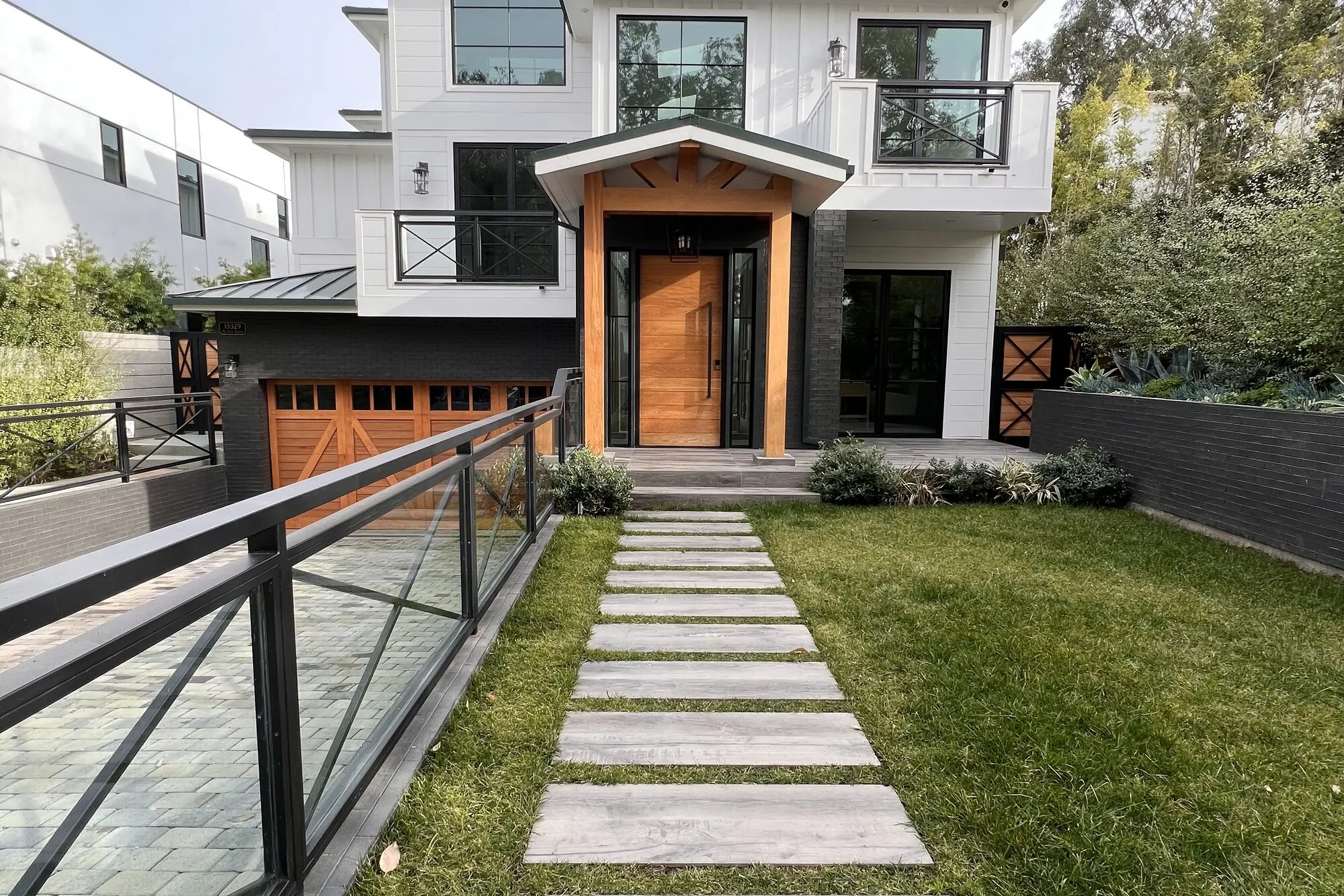 White house with a wood front door and a stone path in Pacific Palisades.