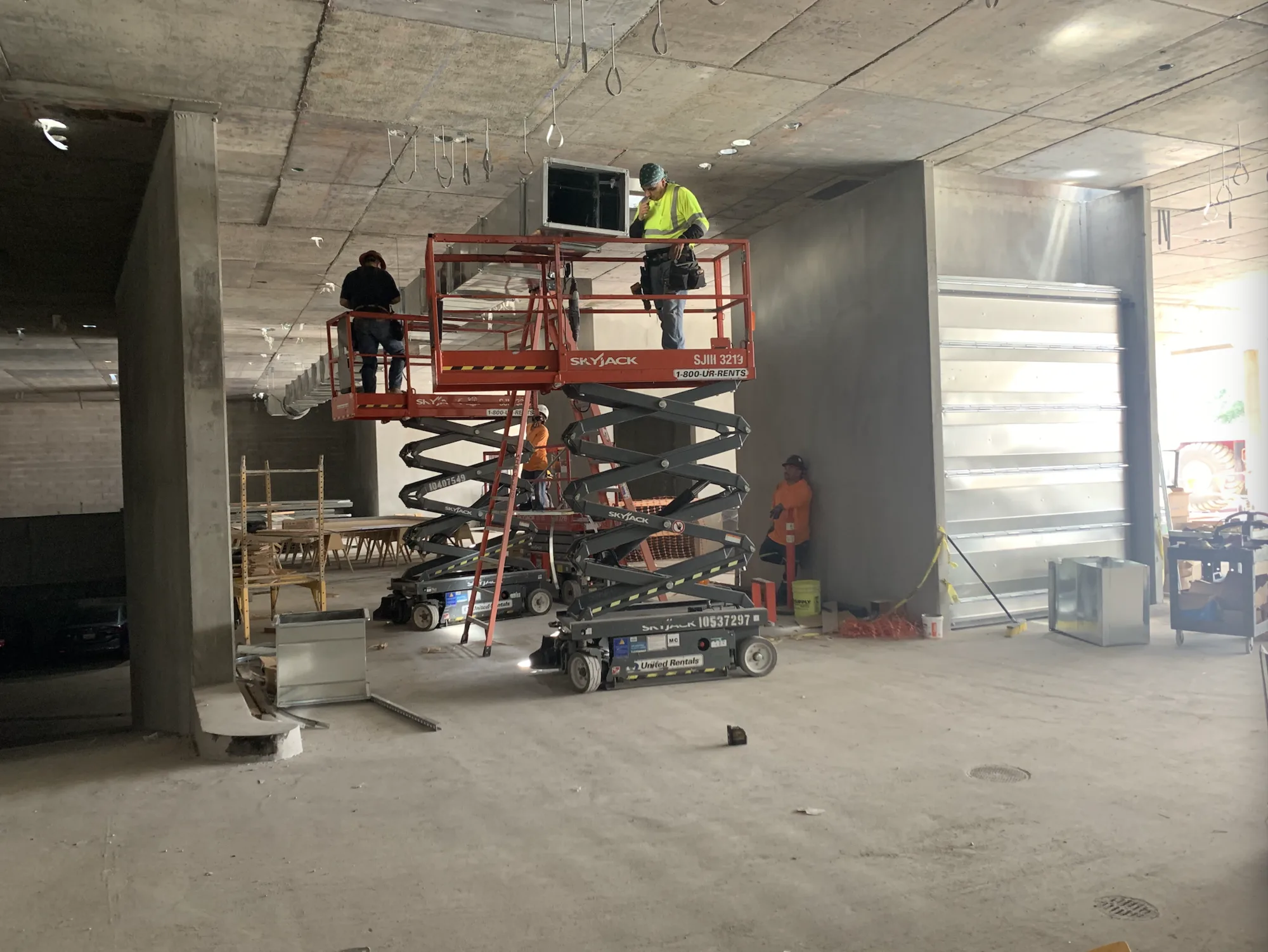 Air Plus crew working from lifts inside a building under construction.